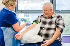 A Bluecrest Health Assessment Specialist preparing a patient for blood drawing.