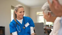 Medical professional speaking to two elderly patients