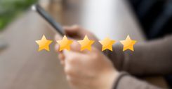 5 gold stars on top of a blurred photo of someone holding a phone